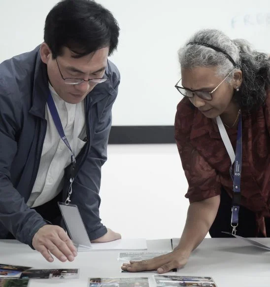 Two workshop participants looking at cards on a table